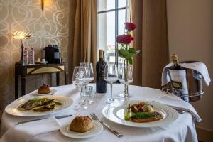 - une table avec deux assiettes de nourriture et des verres à vin dans l'établissement Jehan De Beauce - Teritoria, à Chartres