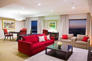 uma sala de estar com um sofá vermelho e uma mesa em Stamford Plaza Sydney Airport Hotel & Conference Centre em Sidney