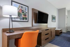 a room with a desk with a television and a chair at Comfort Suites Gainesville Near University in Gainesville