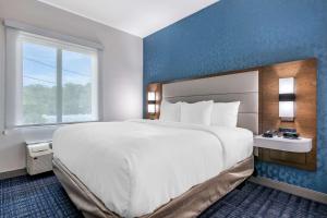 a large white bed in a room with a window at Comfort Suites Gainesville Near University in Gainesville