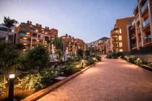 a cobblestone street in a city with tall buildings at Arguineguín Park By Servatur in La Playa de Arguineguín