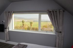 uma janela de quarto com vista para um campo em Atlantic Sunset em Portmagee