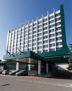 a large hotel with cars parked in front of it at Grand Hotel Napoca in Cluj-Napoca