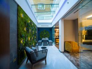 a lobby with a green wall with a chair at Middle Eight - Covent Garden - Preferred Hotels and Resorts in London