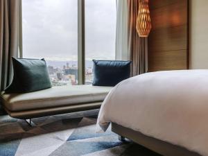 um quarto com uma cama e uma grande janela em Sofitel Mexico City Reforma em Cidade do México