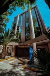 a building with palm trees in front of it at Suites Arquimedes 33 in Mexico City