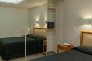 a hotel room with two beds and a mirror at Suites Arquimedes 33 in Mexico City