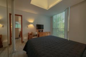 a bedroom with a bed and a desk and a television at Suites Arquimedes 33 in Mexico City