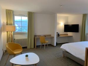 a hotel room with a bed and a desk at Hôtel Restaurant Au Boeuf in Blaesheim