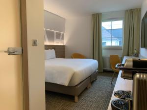 a hotel room with a bed and a window at Hôtel Restaurant Au Boeuf in Blaesheim