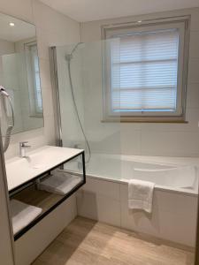 a bathroom with a sink and a tub and a window at Hôtel Restaurant Au Boeuf in Blaesheim