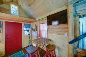 a wooden cabin with a red door and two stools at Tiny House Leadville Colorado in Leadville