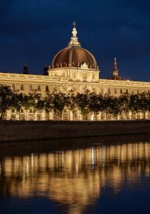 a large building with a dome on top at night at InterContinental Lyon - Hotel Dieu, an IHG Hotel in Lyon