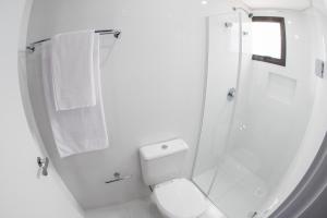 y baño blanco con aseo y ducha. en Laranjeiras Palace Hotel, en Laranjeiras do Sul