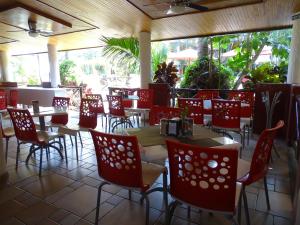 a dining room with red chairs and tables in a restaurant at Hotel Palapa Palace in Tuxtla Gutiérrez