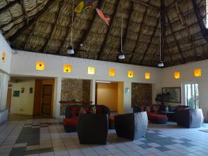 a lobby with couches and a straw roof at Hotel Palapa Palace in Tuxtla Gutiérrez