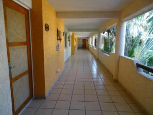 a hallway of a hospital with yellow walls and tile floors at Hotel Palapa Palace in Tuxtla Gutiérrez