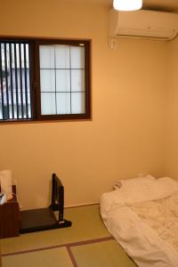 a bedroom with a bed and a window at Guesthouse Engawa in Kyoto