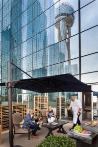 een groep mensen die in stoelen zitten onder een paraplu bij Hyatt Regency Dallas in Dallas