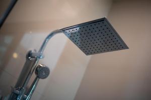 a shower head in a bathroom with a shower at The Pino Hotel Pakchong in Pak Chong