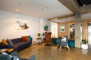 a living room with a couch and chairs at Nesuto Stadium in Auckland