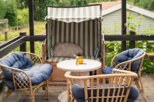 eine Terrasse mit zwei Stühlen und einem Tisch und einem Stuhl mit einem Hund darauf in der Unterkunft Fredensborg Vandrerhjem, i Kongens baghave in Fredensborg