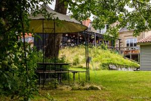 einen Tisch und einen Regenschirm im Gras in der Unterkunft Fredensborg Vandrerhjem, i Kongens baghave in Fredensborg