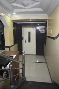 a hallway with a white door in a room at Hotel Sai Vishwa in Shirdi