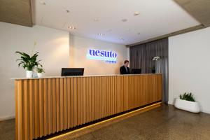 a man standing at the reception desk of a nisso office at Nesuto Stadium in Auckland