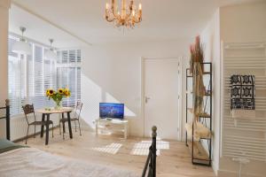 a bedroom with a table and a bed and a chandelier at Boutique Studio Magielsen in Amsterdam