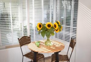 a table with a vase of sunflowers on it at Boutique Studio Magielsen in Amsterdam