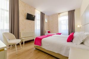 a hotel room with a large bed and a chair at Hotel LX Rossio in Lisbon