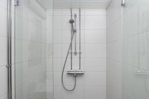 La salle de bains est pourvue d'une douche avec un pommeau de douche. dans l'établissement Omena Hotel Pori, à Pori