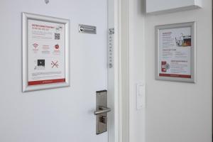 une porte avec deux affiches encadrées dans l'établissement Omena Hotel Pori, à Pori