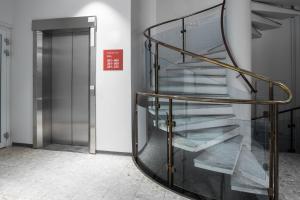 un escalier en colimaçon en verre dans un bâtiment avec porte dans l'établissement Omena Hotel Pori, à Pori