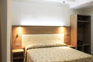 - une chambre avec un lit et une tête de lit en bois dans l'établissement CSI Group - Hotel Metropoli, à Milan