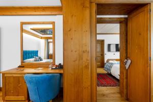 a bedroom with a desk and a mirror and a bed at Hotel Natale in Cortina dʼAmpezzo