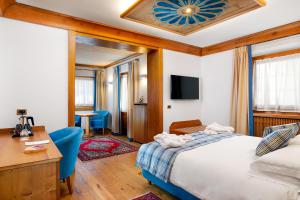 a hotel room with a bed and a desk at Hotel Natale in Cortina dʼAmpezzo