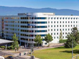 um grande edifício branco com escrita azul em ibis budget Genève Aéroport em Genebra