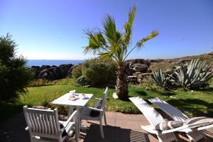 una mesa y sillas con el océano en el fondo en Farol Hotel, en Cascais