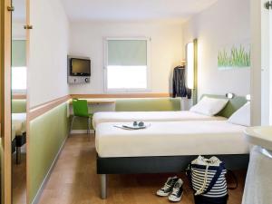 Una cama o camas en una habitación de ibis budget Genève Petit-Lancy