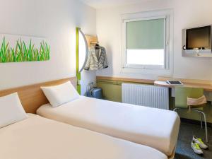 Una cama o camas en una habitación de ibis budget Genève Petit-Lancy