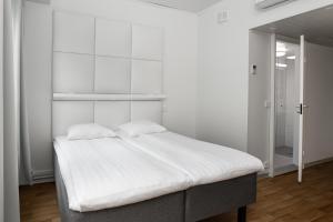 um quarto branco com uma cama com lençóis brancos em Omena Hotel Turku Kauppiaskatu em Turku