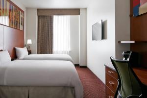 a hotel room with two beds and a desk at Club Quarters Hotel Rittenhouse Square, Philadelphia in Philadelphia