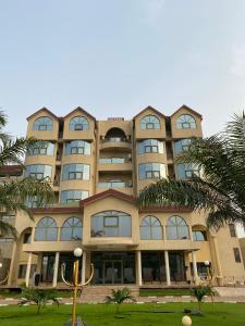 um grande edifício com árvores em frente em Hôtel Sancta Maria em Lomé