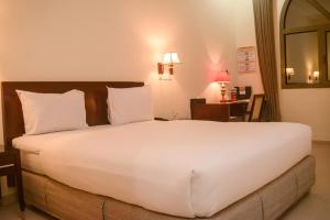 uma grande cama branca num quarto de hotel em Hôtel Sancta Maria em Lomé