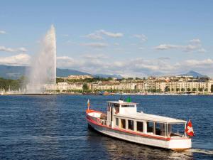 um barco na água com uma fonte ao fundo em ibis budget Genève Aéroport em Genebra