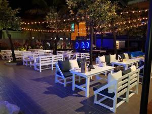 a restaurant with white tables and chairs and lights at Fulidun Hotel Kenting in Hengchun South Gate