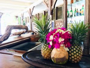 dois ananases estão sentados numa mesa com flores em White Elephant Sea Lodge em Melinde