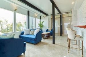 a living room with blue furniture and large windows at HOTEL HIMALAYA SEA in Ito